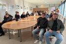 Personengruppe an ovalem Tisch in einem Raum