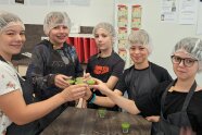 5 Personen mit Hauben prosten sich mit Gläschen zu.